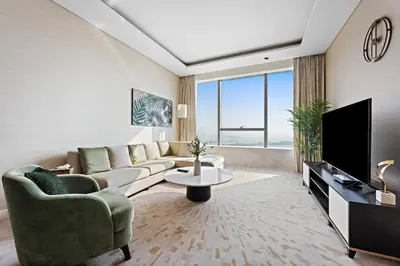 a living room with a couch and a tv at StoneTree - Luxurious 1BR with Amazing Sea View in Dubai