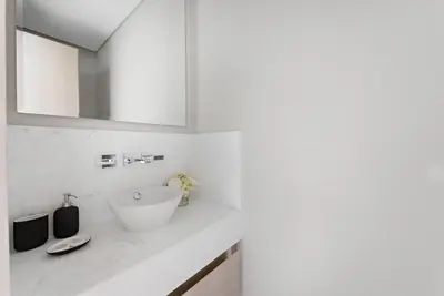 a white bathroom with a sink and a mirror at StoneTree - Luxurious 1BR with Amazing Sea View in Dubai