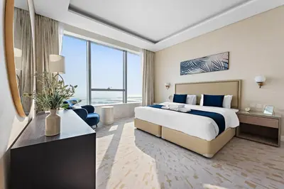 a hotel room with a bed and a large window at StoneTree - Luxurious 1BR with Amazing Sea View in Dubai