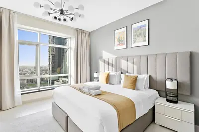 a bedroom with a large bed with a large window at StoneTree - Stylish 1BR & Pool with Burj Khalifa Views in Dubai