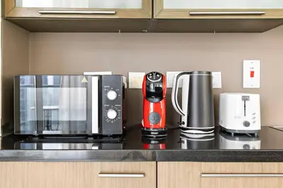 a kitchen counter with a coffee maker and appliances on it at StoneTree - Stylish 1BR & Pool with Burj Khalifa Views in Dubai
