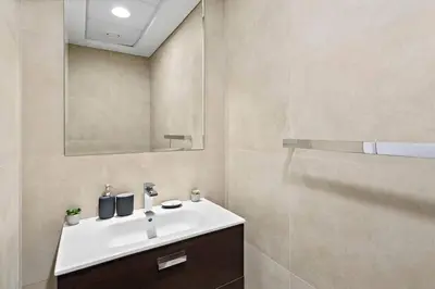 a bathroom with a white sink and a mirror at StoneTree - Furnished 2 BR with Maids Room in Dubai Marina in Dubai