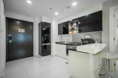 a kitchen with black cabinets and a white counter top at StoneTree - Furnished 1BR in Prime Location in Dubai