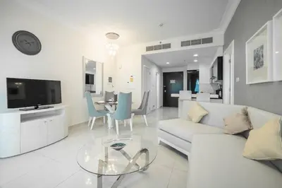 a living room with a white couch and a table at StoneTree - Furnished 1BR in Prime Location in Dubai