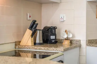a kitchen counter with a coffee maker on it at Cozy Haven with Spiritual Charm in JLT in Dubai