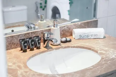a bathroom counter with a white sink and a mirror at Cozy Haven with Spiritual Charm in JLT in Dubai