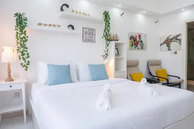 a bedroom with a large white bed with blue pillows at Cozy Haven with Spiritual Charm in JLT in Dubai