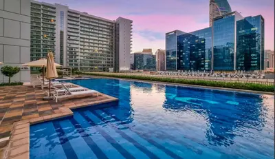 a swimming pool with a city skyline in the background at New 1 bedroom with Canal View - Close to Downtown in Dubai