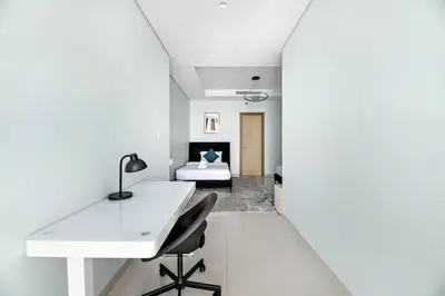 a white room with a desk and a bed at StoneTree - Furnished 2 BR with City View in Dubai