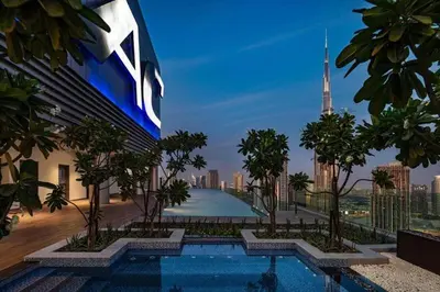 a building with a swimming pool with a view of a city at StoneTree - Furnished 2 BR with City View in Dubai