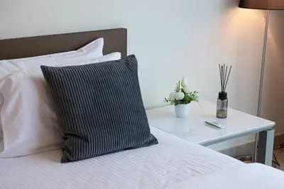 a black and white pillow on a bed with a table at DIFC Luxurious Spacious 1-Bed Apt in a Prime Location in Dubai