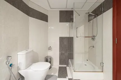 a bathroom with a toilet and a shower and a tub at DIFC Luxurious Spacious 1-Bed Apt in a Prime Location in Dubai