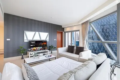 a living room with a white couch and a large window at DIFC Luxurious Spacious 1-Bed Apt in a Prime Location in Dubai