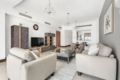 a living room with two white couches and a table at StoneTree - Luxurious 1 BR with Beach Access at Fairmont The Palm in Dubai