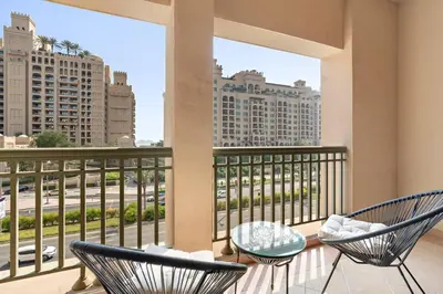 a balcony with chairs and a view of a city at StoneTree - Luxurious 1 BR with Beach Access at Fairmont The Palm in Dubai