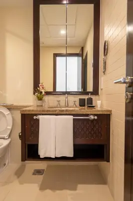a bathroom with a sink and a toilet and a mirror at INA HOMES - 2BHK Residences Tower 1 in Dubai
