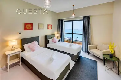 a hotel room with two beds and a couch at Jumeirah Beach Residence - Rimal 4, Dubai Marina in Dubai