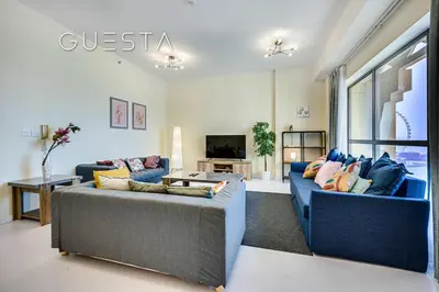 a living room with two blue couches and a tv at Jumeirah Beach Residence - Rimal 4, Dubai Marina in Dubai