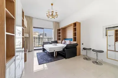 a living room with a table and a couch at StoneTree - Modern Style of Studio in Resortz by Danube in Dubai