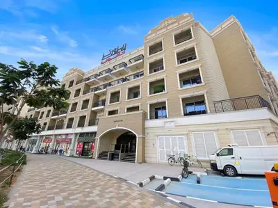 a large building with a van parked in front of it at StoneTree - Modern Style of Studio in Resortz by Danube in Dubai