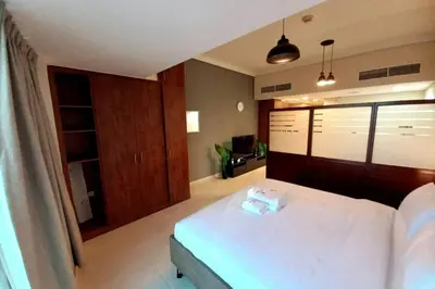 a bedroom with a bed with two towels on it at StoneTree - Furnished Studio near Metro Station in Dubai
