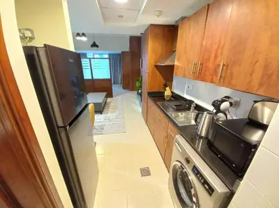 a kitchen with a stainless steel refrigerator and a stove at StoneTree - Furnished Studio near Metro Station in Dubai