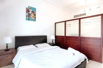 a bedroom with a large bed with white sheets at StoneTree - Furnished Studio with Lake View and near Metro in Dubai