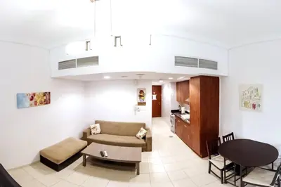 a living room with a couch and a table at StoneTree - Furnished Studio with Lake View and near Metro in Dubai