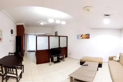 a living room with a couch and a table at StoneTree - Furnished Studio with Lake View and near Metro in Dubai