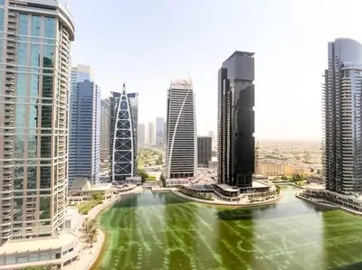 a city with a green river in the middle at StoneTree - Furnished Studio with Lake View and near Metro in Dubai