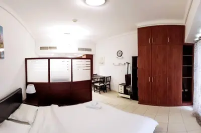 a bedroom with a bed and a table in a room at StoneTree - Furnished Studio with Lake View and near Metro in Dubai