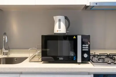 a microwave oven sitting on top of a kitchen counter at Coastal Bay 1 Bedroom in Dubai
