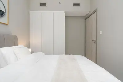 a bedroom with a white bed and an open door at Coastal Bay 1 Bedroom in Dubai