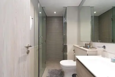 a bathroom with a toilet and a glass shower at Coastal Bay 1 Bedroom in Dubai