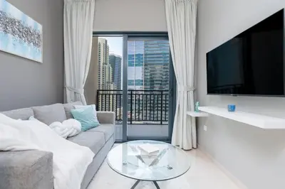 a living room with a couch and a glass table at Coastal Bay 1 Bedroom in Dubai