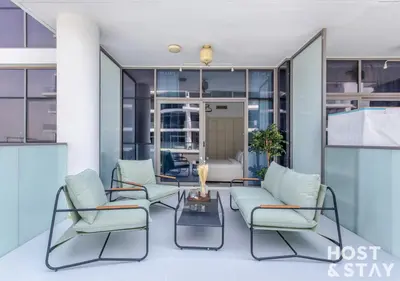 a living room with two chairs and a table at Studio in Loreto 1A, DAMAC Hills - Host & Stay in Dubai