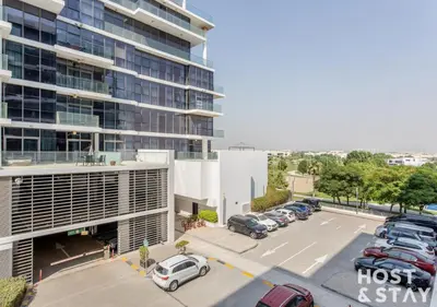 an aerial view of a parking lot in front of a building at Studio in Loreto 1A, DAMAC Hills - Host & Stay in Dubai