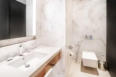 a white bathroom with a sink and a mirror at Prime Retreats @ Address Residence Opera By Emaar in Dubai