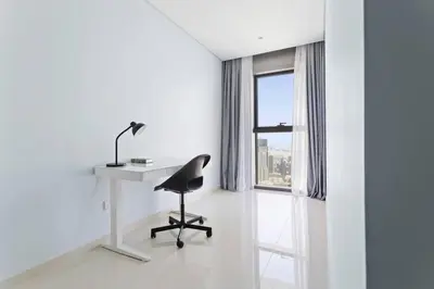 a white room with a desk and a chair and a window at StoneTree - Furnished 2BR with Luxurious Style in Dubai