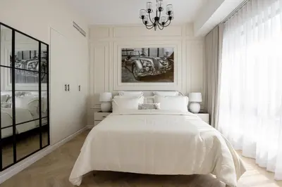 a white bedroom with a large bed and a chandelier at Beautiful stylish 1 bedroom by the JBR beach ! in Dubai