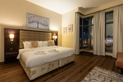 a bedroom with a large bed and a large window at BEAUTIFUL HUGE 2 BED ROOM APARTMENT in Dubai