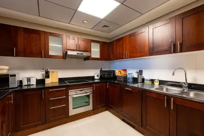 a kitchen with wooden cabinets and a sink at BEAUTIFUL HUGE 2 BED ROOM APARTMENT in Dubai