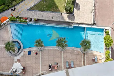 an overhead view of a swimming pool with palm trees at StoneTree - Stylish Studio near Metro Station in Dubai