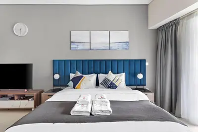 a bedroom with a large bed with two shoes on it at StoneTree - Stylish Studio near Metro Station in Dubai