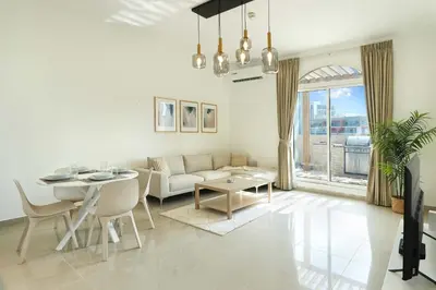 a living room with a couch and a table at Plaza Residences - 2BR Apartment - Allsopp&Allsopp in Dubai