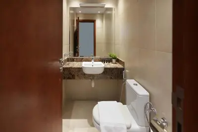 a bathroom with a white toilet and a sink at Plaza Residences - 2BR Apartment - Allsopp&Allsopp in Dubai