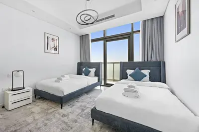 a bedroom with two beds and a window at StoneTree - Luxurious 2 BR Apartment with Stunning View in Dubai