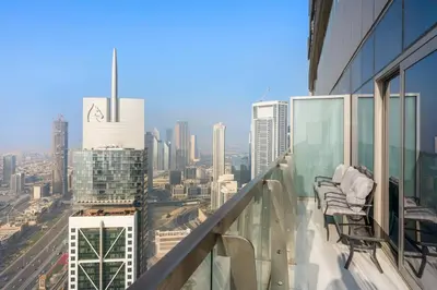 a balcony with chairs and a view of a city at StoneTree - Luxurious 2 BR Apartment with Stunning View in Dubai