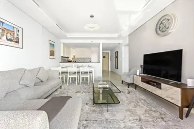 a living room with a couch and a tv at StoneTree - Luxurious 2 BR Apartment with Stunning View in Dubai