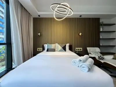a bedroom with a large bed with towels on it at Trophy - Private Office Solace Suite in Dubai